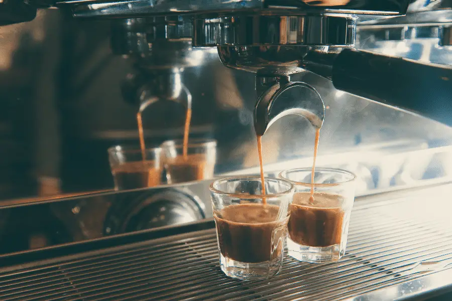Double shot of espresso being pulled into two glasses.