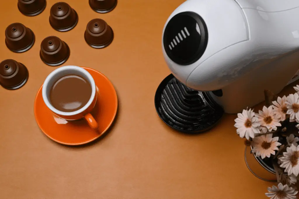 Image of a pod coffee brewer with a cup of coffee. 