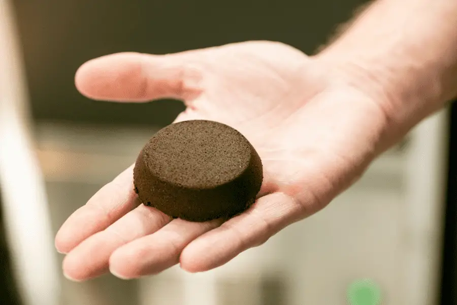 Person holding espresso puck after brewing.