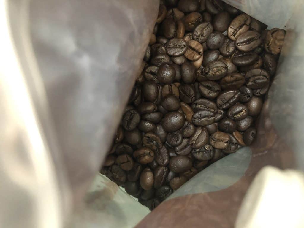 Image of medium and dark roasted beans in a bag.